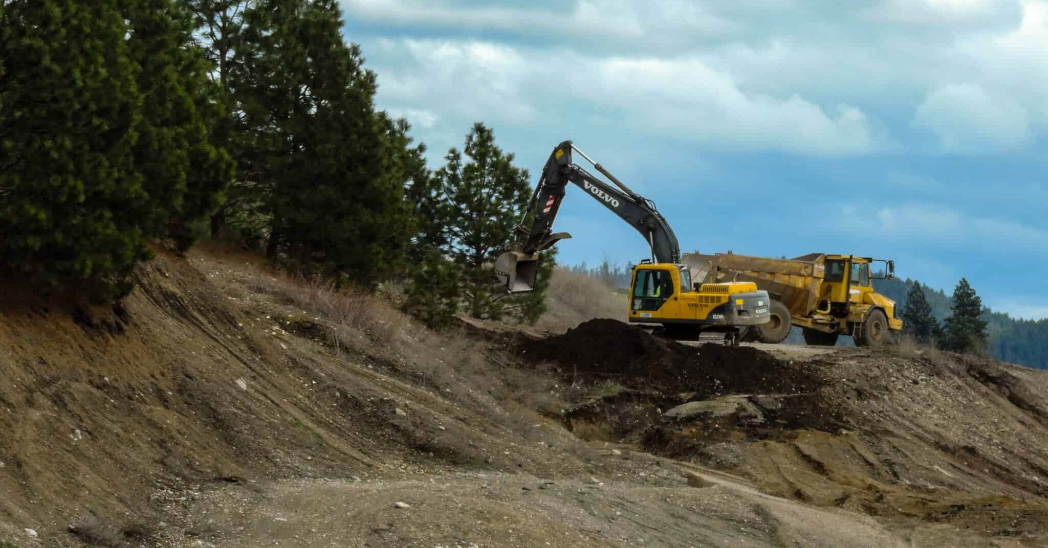 Rimelig hjemmeside for maskinentreprenør, hvor toppbildet er presentert en gravermaskin og dumper